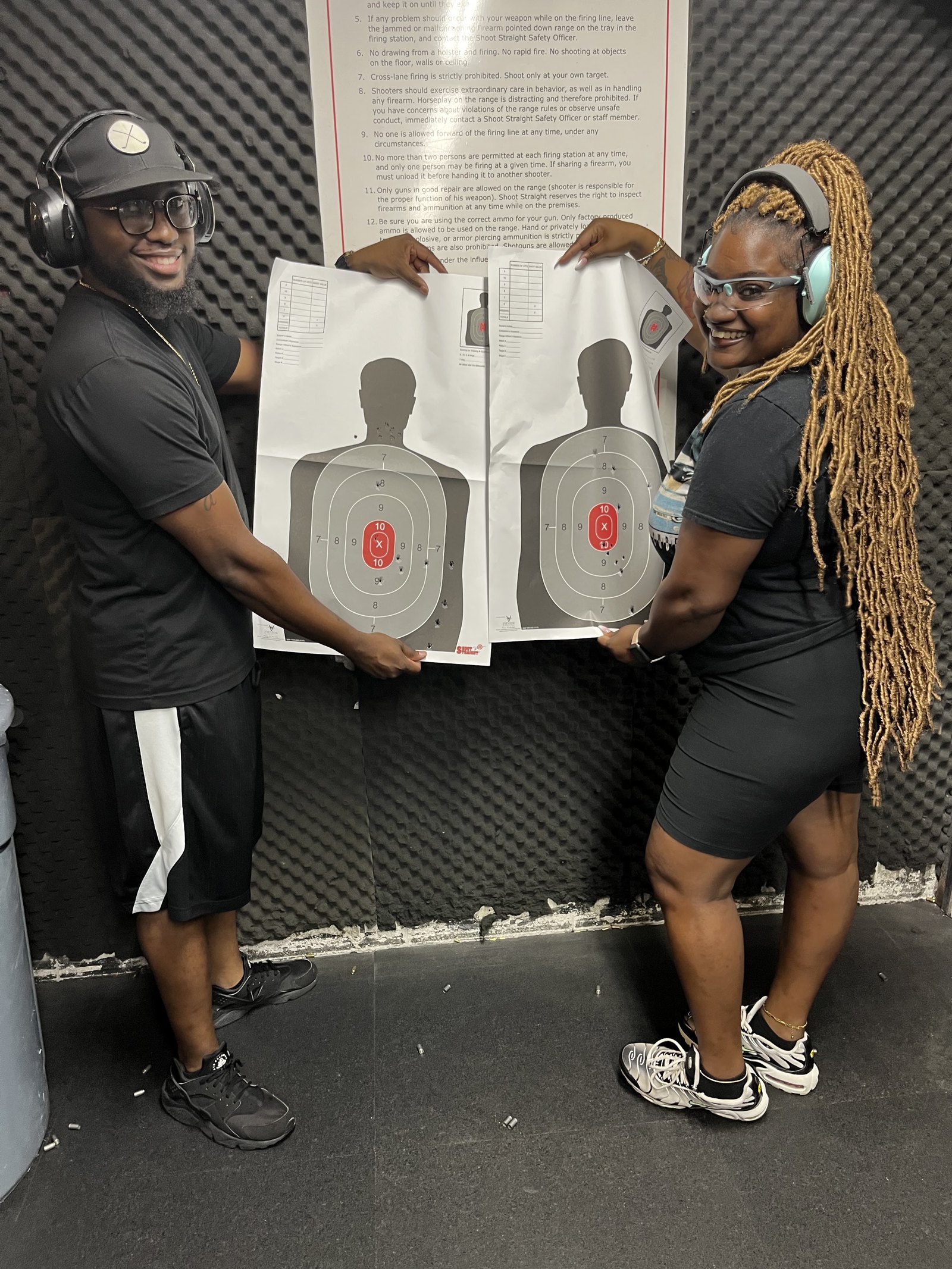 Instructors holding scored targets at the range